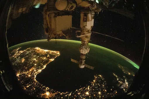 Вид на Землю сквозь иллюминатор МКС.