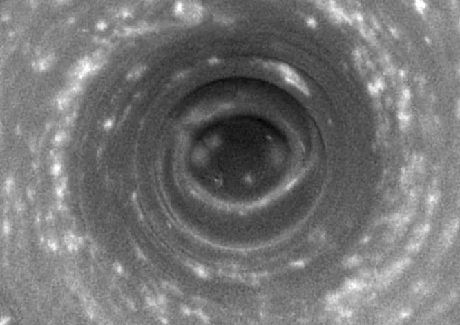 Таинственный глаз Сатурна. Над южным полюсом Сатурна раскинулся невообразимый 32-километровый тайфун. На Земле подобные циклоны перемещаются по морской поверхности, но на Сатурне нет морей, и его тайфуны не покидают полюсов. Эту атмосферную тайну окольцованного великана ещё предстоит разгадать.