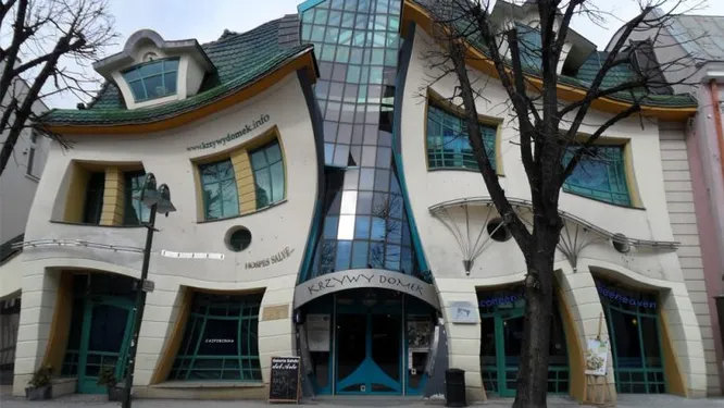 «Изогнутый дом» - Сопот, Польша. Еще одно творение сумрачного польского гения. Его архитектура была вдохновлена волшебными рисунками польских художников Пьера Дальберга и Яна Марцина Шанцера. Стены дома изогнуты наподобие отражения, которое можно увидеть в кривом зеркале. Технически, правда, это не совсем «дом» - сейчас в нем располагается торговый центр.  