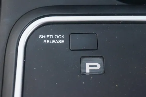 Что делает кнопка Shift Lock Release рядом с селектором коробки передач?