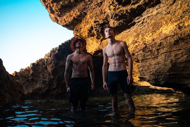 Похудение для мужчин: две стройный парней стоят в воде и смотрят наверх